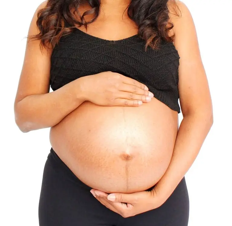 Pregnant woman with her hands on her stomach